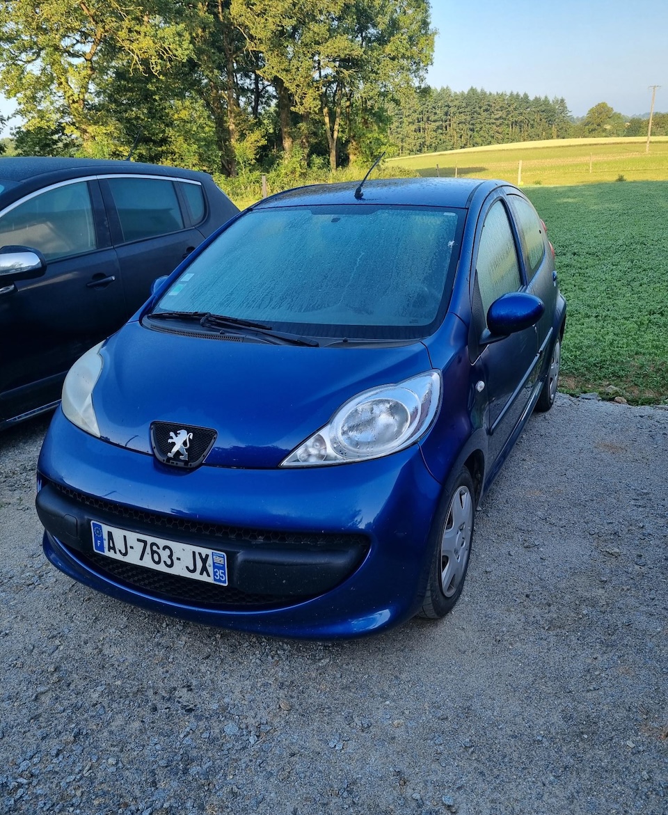 Voiture Peugeot 107 bleue en attente de location au garage